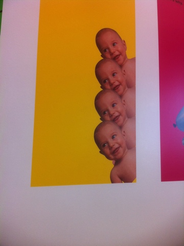 four identical stacked baby heads