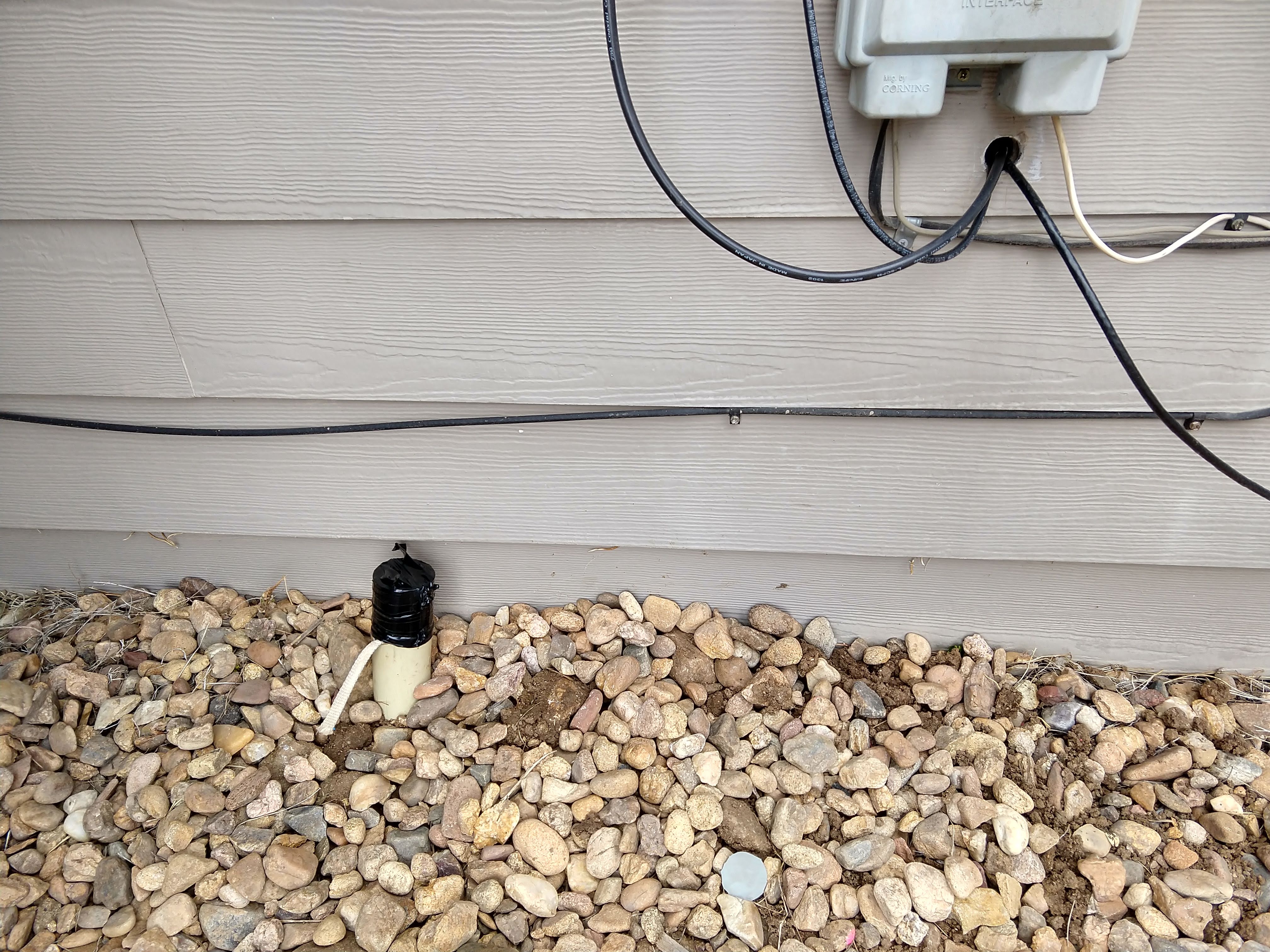 a few inches of conduit stick up above ground next to siding